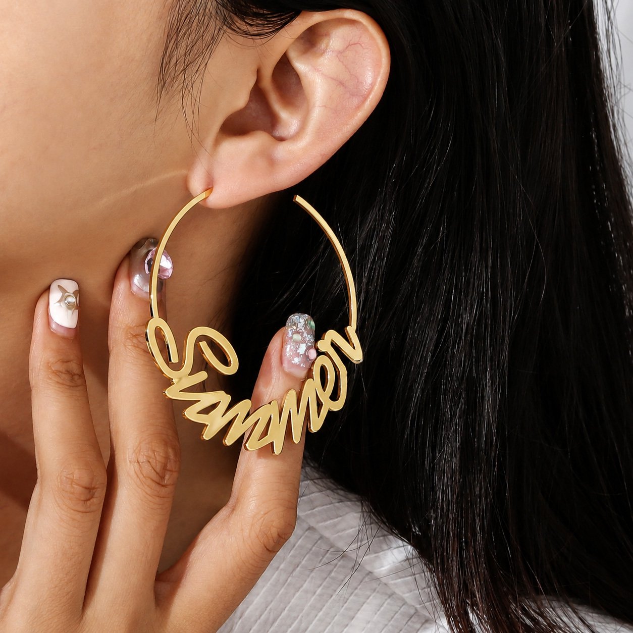 Woman wearing a large gold Custom Name Hoop Earring featuring a personalized cursive name design
