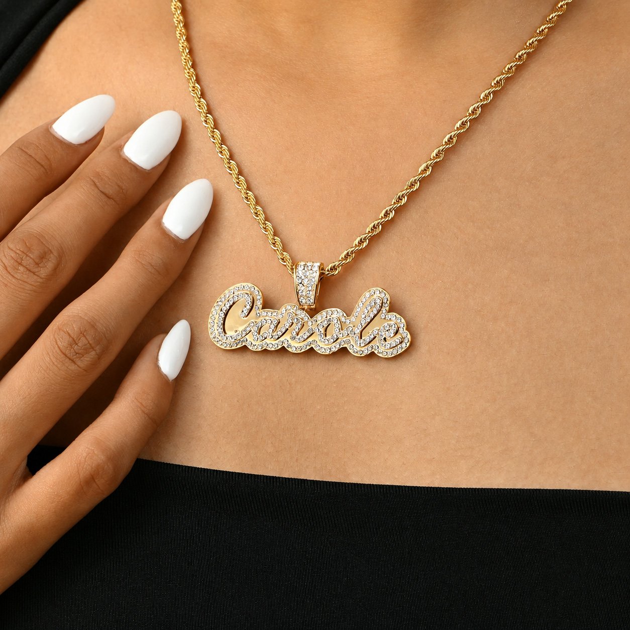 Crystal Cursive Name Necklace in 18K gold with sparkling crystals and a rope chain, modeled with a black top and white manicure