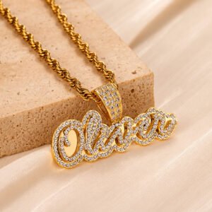 Gold Crystal Cursive Name Necklace with sparkling custom name pendant, crystal-studded bail, and rope chain displayed on cream satin