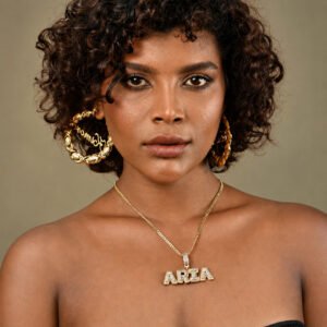 Model wearing a gold Unisex Premium Bling Name Necklace personalized with “ARIA”