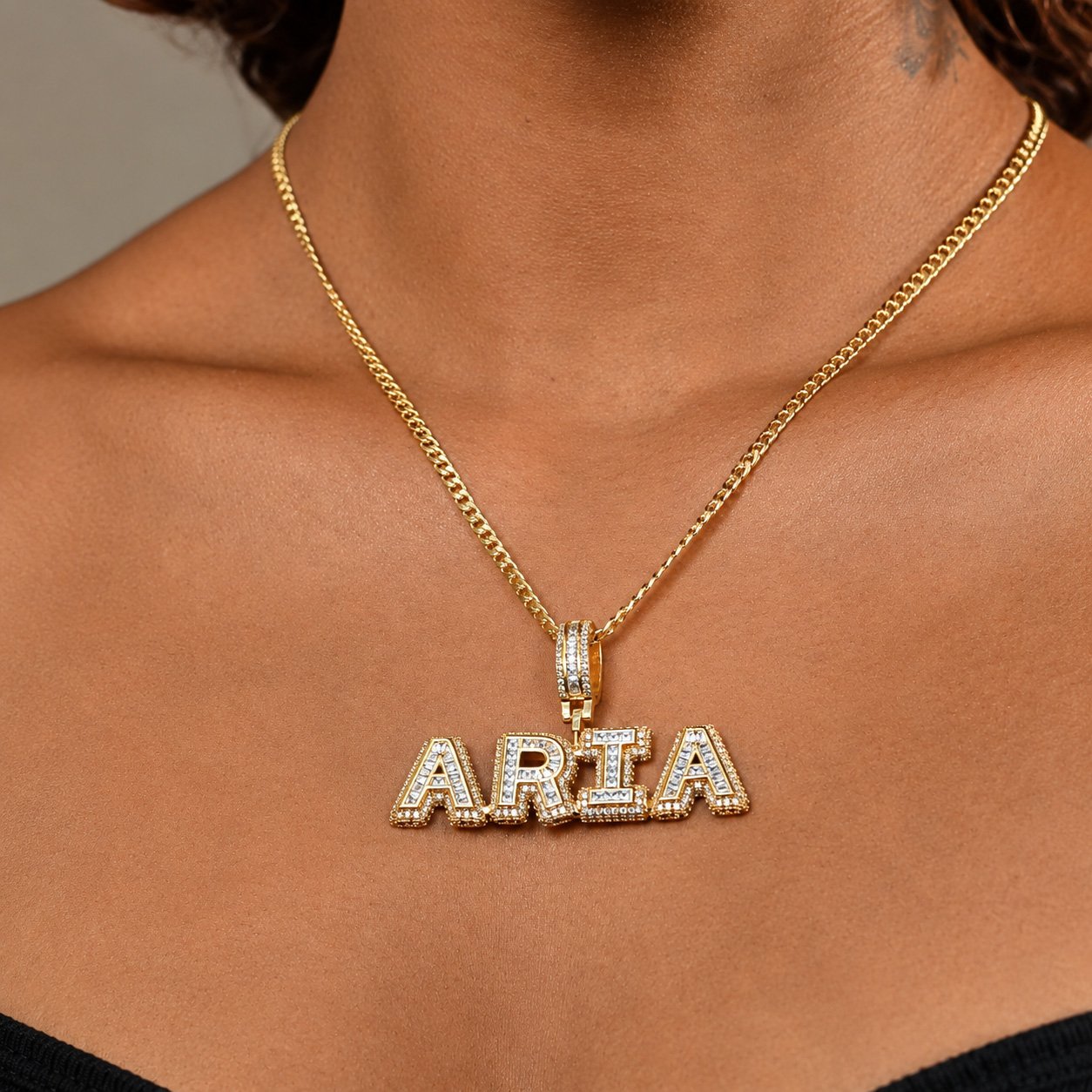 Unisex Premium Bling Name Necklace in gold with the name “ARIA,” worn by a model