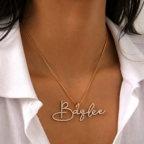 Personalized gold color script crystal name necklace worn on a white shirt