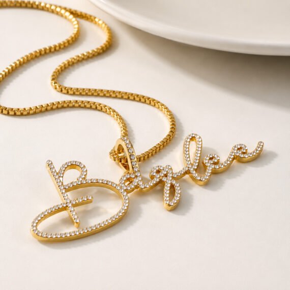 Personalized gold script crystal name necklace with cubic zirconia on a white minimalist background